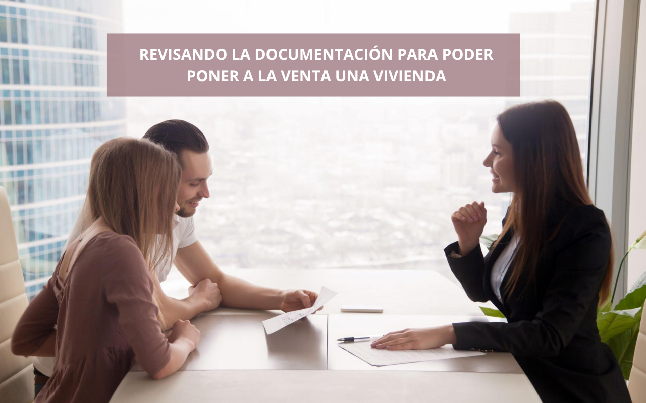 Asesora inmobiliaria revisando con unos propietarios la documentación necesaria para vender una vivienda.